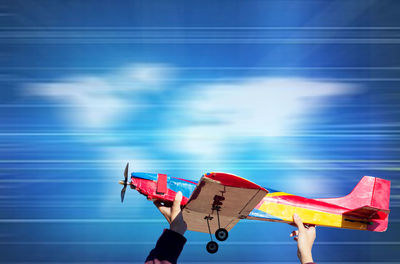 Side view of toy airplane against blue sky