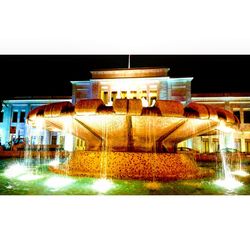 Illuminated building against clear sky at night