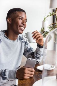 Young man using mobile phone on table