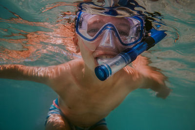 Portrait of shirtless boy swimming in sea