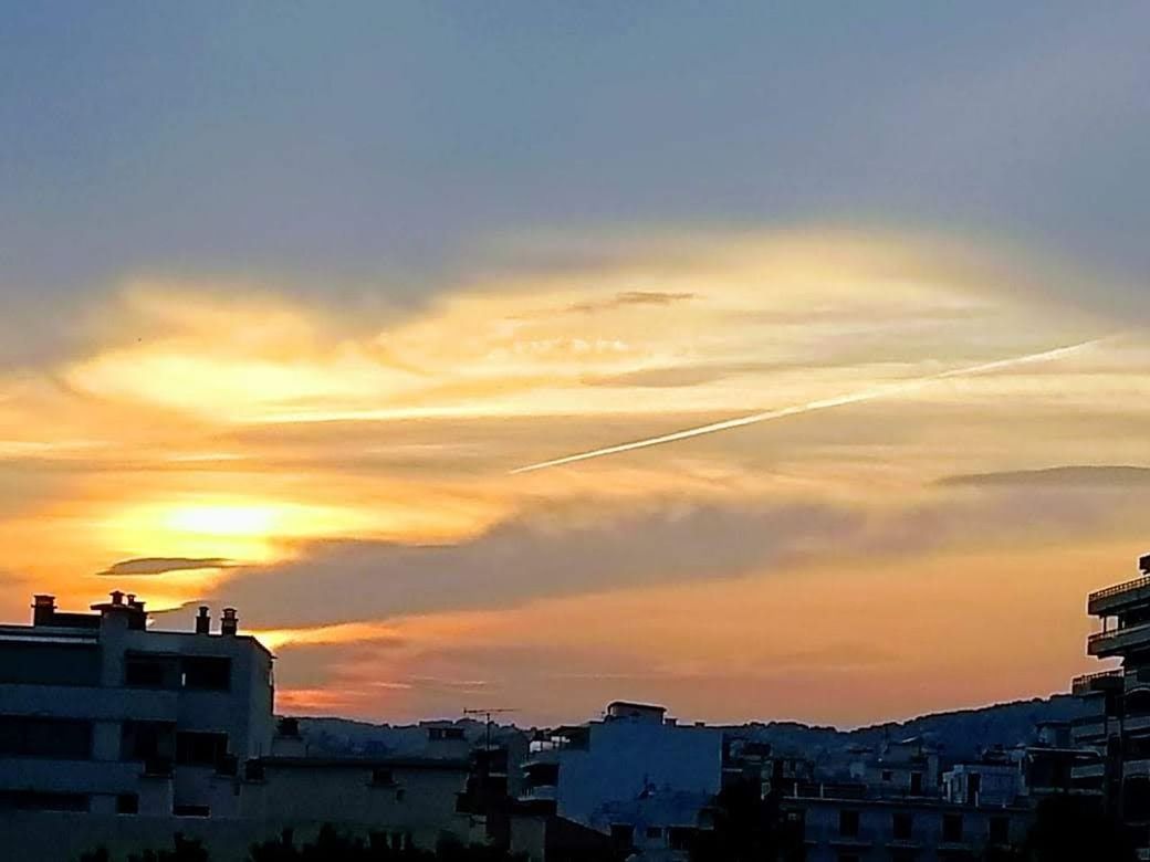 SILHOUETTE BUILDINGS IN TOWN AGAINST SKY DURING SUNSET