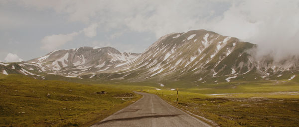 Road amidst mountains against sky