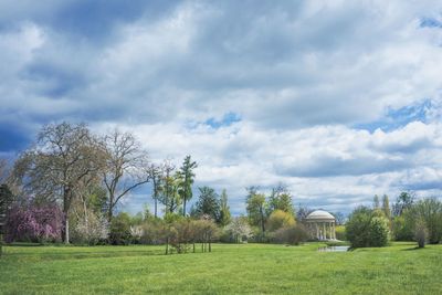 Scenic view of grassy field against cloudy sky