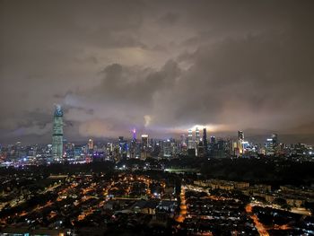 Illuminated cityscape against sky at night