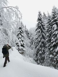 Rear view of person on snowcapped mountain during winter