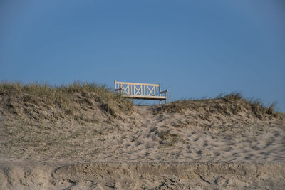 Text on sand at beach against clear blue sky