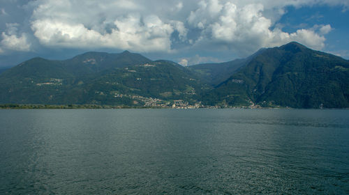 Scenic view of sea by mountains against sky