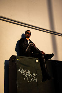 Full length of man standing against wall