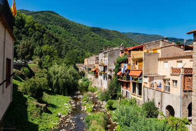 Panoramic view of buildings and trees against blue sky