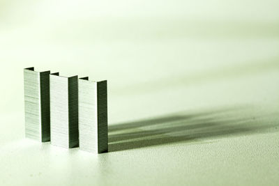 Close-up of paper stack on table against white background