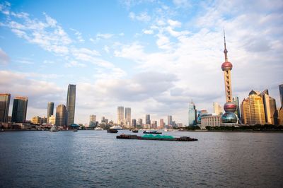View of buildings in city against cloudy sky