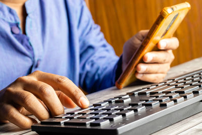 Midsection of man using calculator