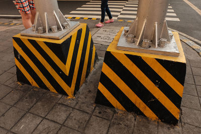 Low section of woman standing on sidewalk