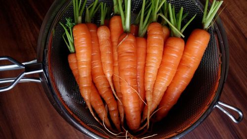 High angle view of carrots in strainer on table