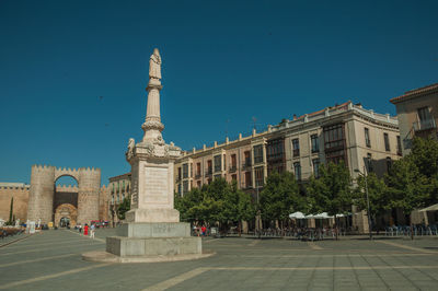 Avila, spain. santa teresa de jesus square and people in front of the alcazar gate at avila. 