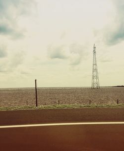 Electricity pylon on field against sky