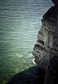 Rock formation by sea against sky