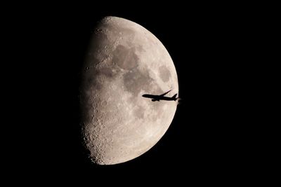 Low angle view of airplane against sky at night