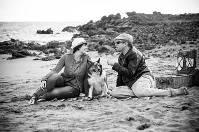 Couple with dog relaxing on beach