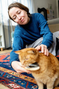 Portrait of young woman with dog at home