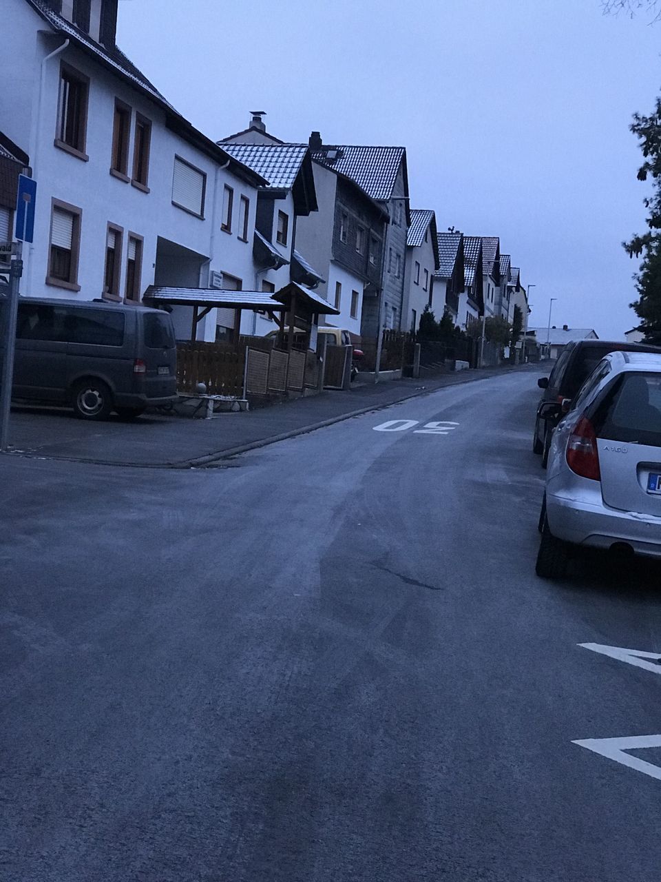 CARS ON ROAD BY BUILDINGS AGAINST SKY