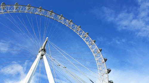 Low angle view of ferris wheel against blue sky