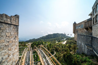 Panoramic view of railroad tracks amidst buildings against sky