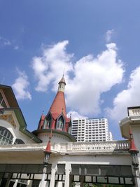 Low angle view of buildings against cloudy sky