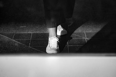 Low section of woman standing on tiled floor