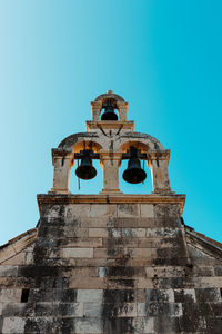 Low angle view of old building against clear blue sky