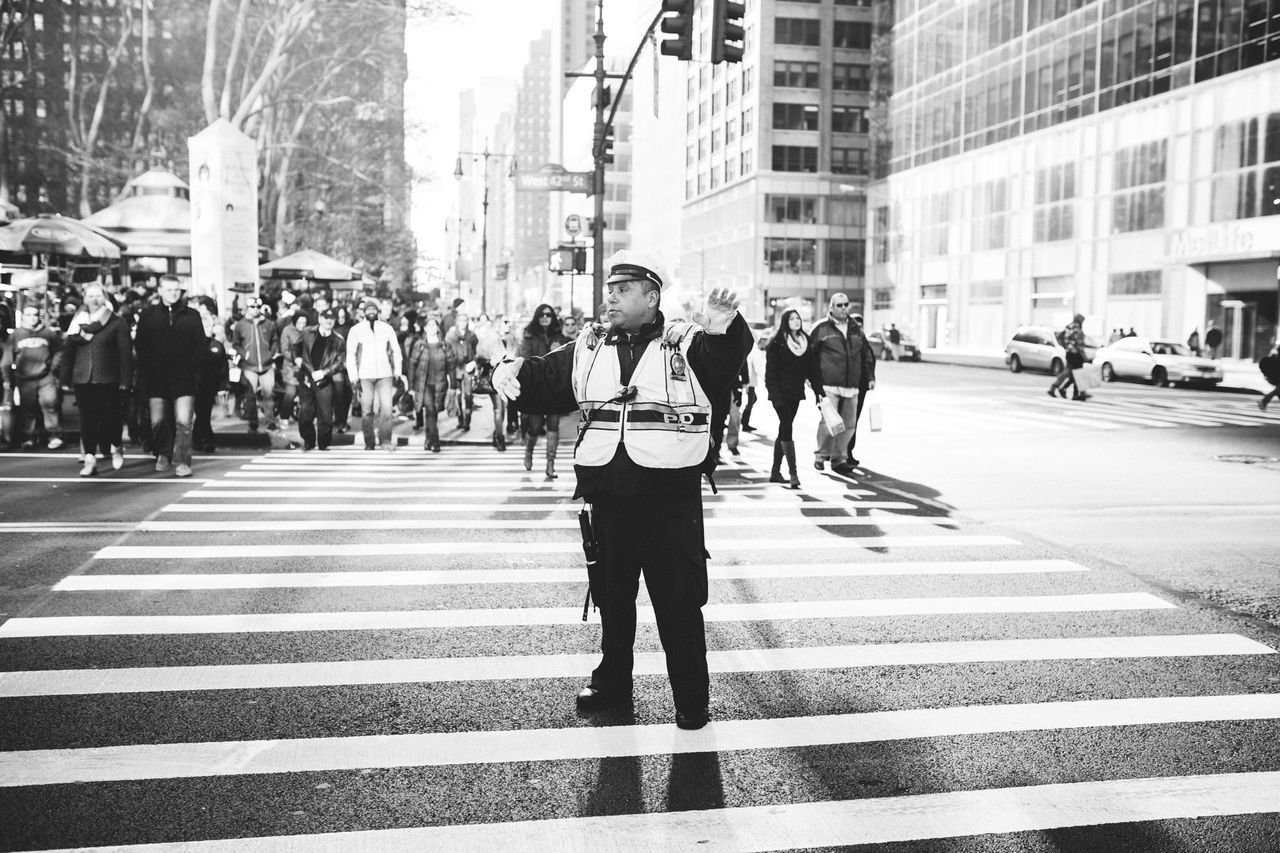 building exterior, walking, city, architecture, street, men, city life, built structure, person, lifestyles, zebra crossing, large group of people, full length, city street, rear view, the way forward, on the move, leisure activity, pedestrian