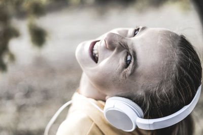 Close-up portrait of smiling girl listening music 