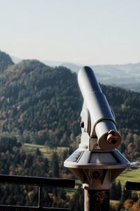 Close-up of coin-operated binoculars against mountain