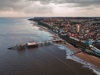 High angle view of cityscape by sea against sky