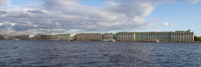 Buildings in city against cloudy sky