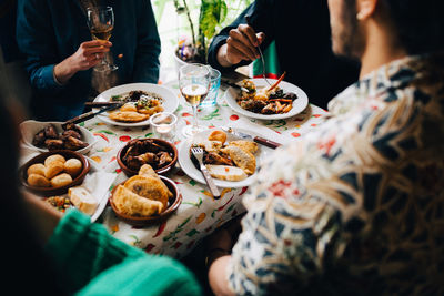 High angle view of young multi-ethnic friends enjoying lunch while sitting at table in restaurant