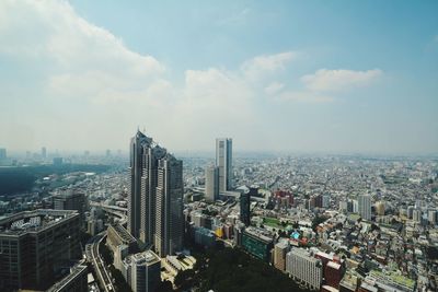 Tokyo metropolitan government building and cityscape against cloudy sky