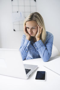 Frustrated businesswoman staring laptop while working at home