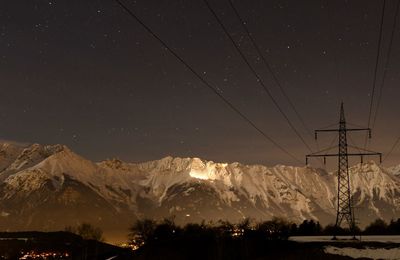 Scenic view of snowcapped mountains against sky at night