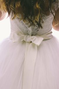 Rear view of woman standing on bed