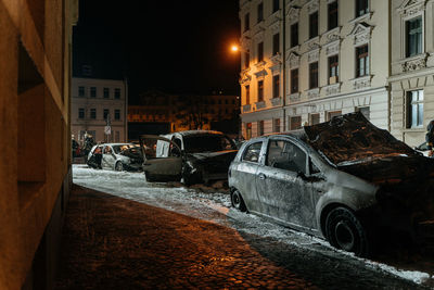 Cars parked on street by buildings in city at night