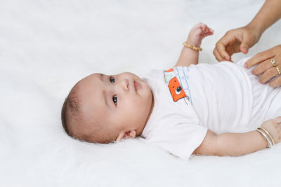 Portrait of cute baby lying on bed at home