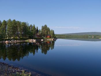 Scenic view of lake by building against clear sky