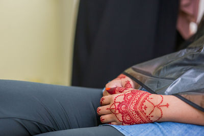 Midsection of woman sitting on chair at home