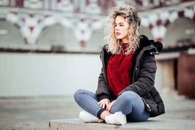 Full length of woman sitting outdoors