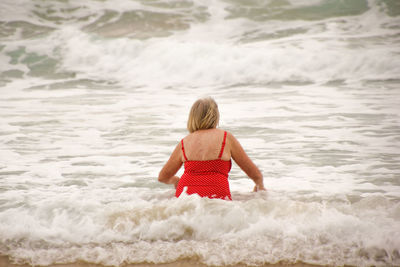 Rear view of boy standing on beach