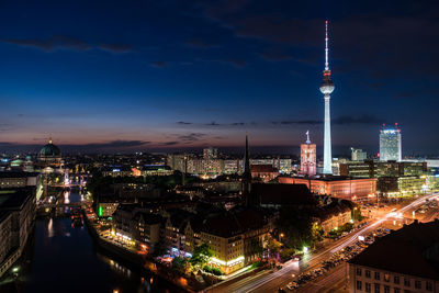 Illuminated buildings in city against sky at night