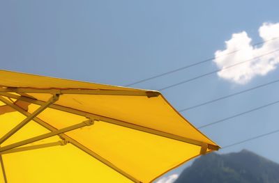 Low angle view of yellow parasol against sky