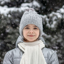 Portrait of a girl walking outdoors against the backdrop of a christmas tree in the snow. 