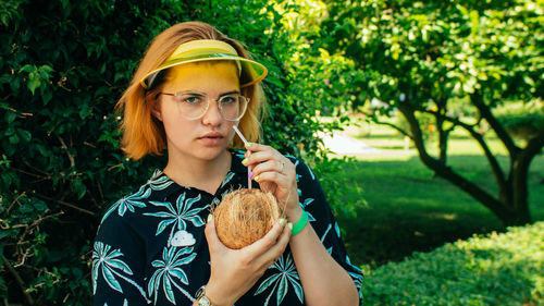 Portrait of young woman holding plant